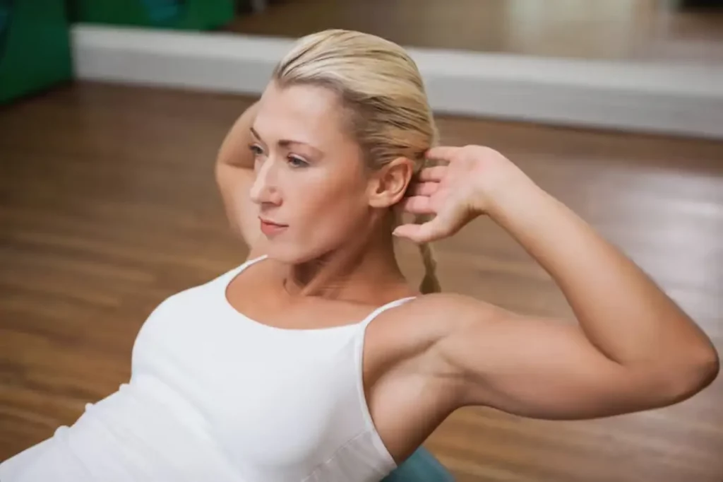 Woman doing abdominal crunches on fitness ball in gym