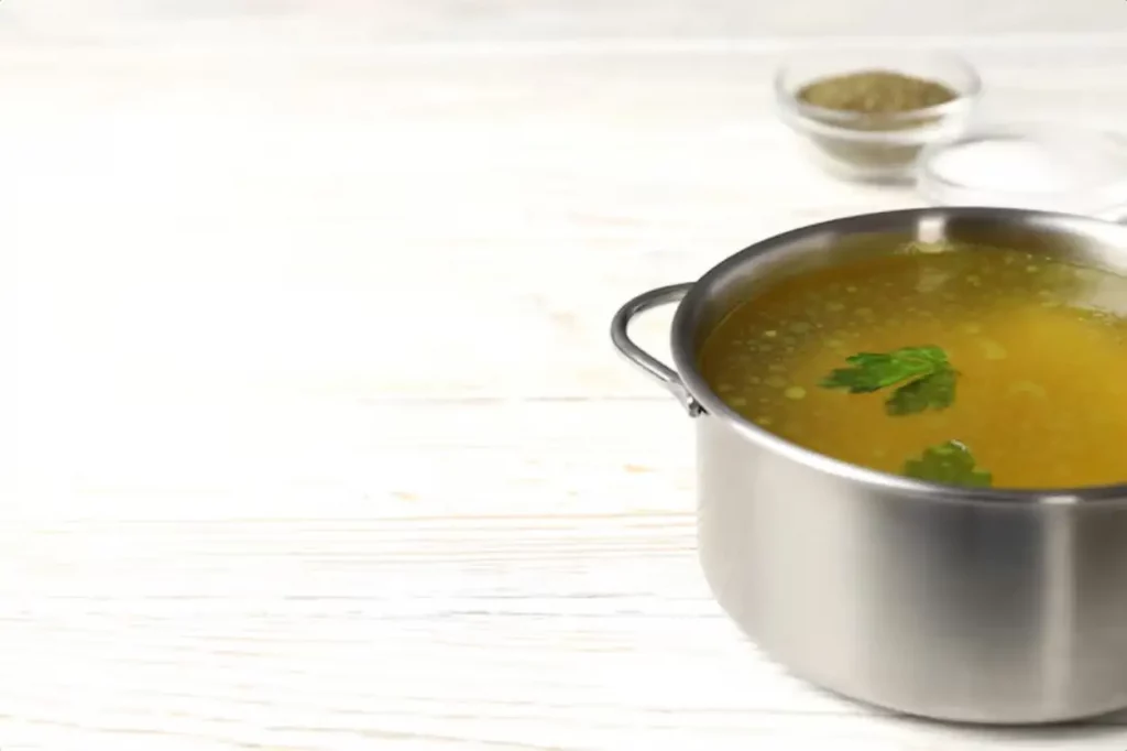 Concept of tasty food with broth on white wooden background