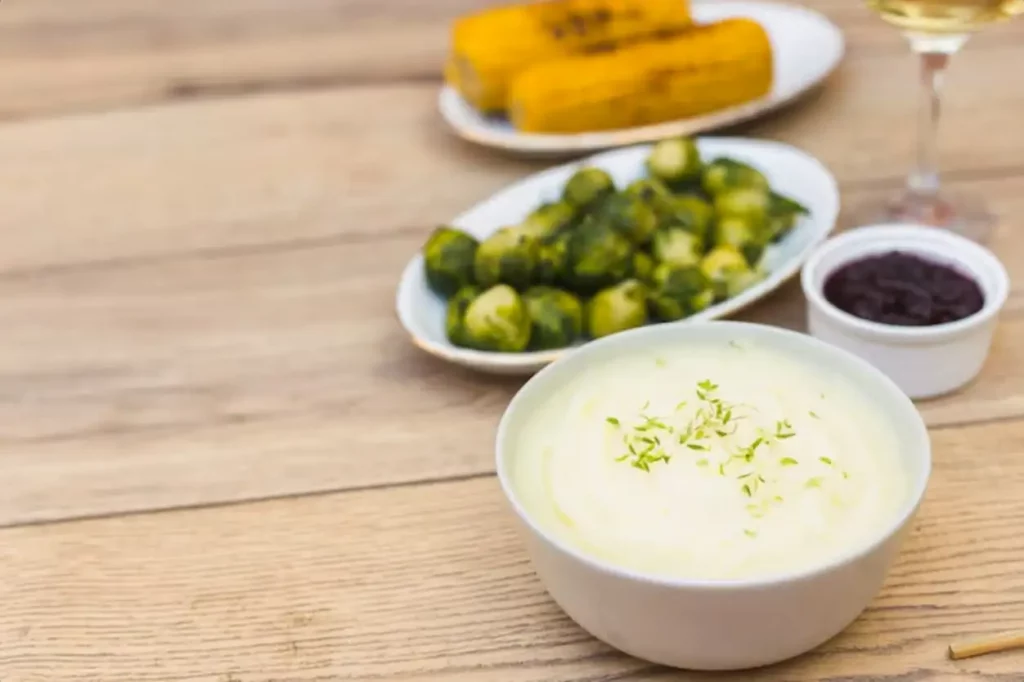 Potato puree in bowl with brussels sprouts